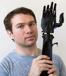 student holding a prosthetic arm