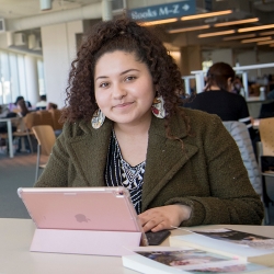 young Latino women in library using ipad computer