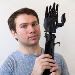 student holding a prosthetic arm
